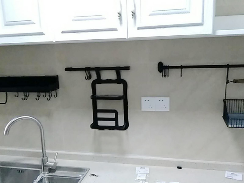 廚房五金掛件安裝：五金件的安裝一般是在瓷磚鋪貼完成后，在瓷磚上鉆孔，然后將木楔嵌入孔中，然后在上面用螺絲或膨脹螺絲將五金掛件進(jìn)行固定。
掛件在使用過程中通常會(huì)承受一定重量，加上用力按壓、拽拉或安裝不牢固等，過段時(shí)間后，多少會(huì)出現(xiàn)松動(dòng)、脫落的現(xiàn)象。在選購此類產(chǎn)品時(shí)，最好選擇帶有擋條的產(chǎn)品，確保上面的物品不會(huì)滑落傷人。另外，在使用前可查看其說明，注意其最大承受重量的限度，不要超重而引起安全隱患。