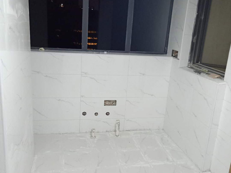 衛(wèi)生間瓷磚鋪貼：基層處理：把沾在基層上的浮漿、落地灰等用暫子或鋼絲刷清理掉，再用掃帚將浮土清掃干凈。找標(biāo)高：根據(jù)水平標(biāo)準(zhǔn)線和設(shè)計厚度，在四周墻、柱上彈出面層的上平標(biāo)高控制線。排磚：將房間依照磚的尺寸留縫大小，排出磚的放置位置，并在基層地面彈出十字控制線和分格線。鋪設(shè)結(jié)合層砂漿：鋪設(shè)前應(yīng)將基底濕潤，并在基底上刷一道素水泥漿或界面結(jié)合劑，隨刷隨鋪設(shè)攪拌均勻的干硬性水泥砂漿。鋪磚時應(yīng)先在房間中間按照十字線鋪設(shè)十字控制磚，之后按照十字控制磚向四周鋪設(shè)，并隨時用2m靠尺和水平尺檢查平整度。大面積鋪貼時應(yīng)分段、分部位鋪貼。養(yǎng)護(hù)：當(dāng)磚面層鋪貼完24h內(nèi)應(yīng)開始澆水養(yǎng)護(hù)，養(yǎng)護(hù)時間不得小于7d。