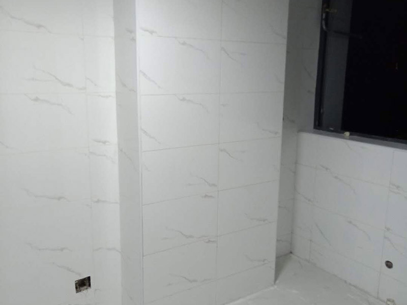 衛(wèi)生間瓷磚鋪貼：基層處理：把沾在基層上的浮漿、落地灰等用暫子或鋼絲刷清理掉，再用掃帚將浮土清掃干凈。找標(biāo)高：根據(jù)水平標(biāo)準(zhǔn)線和設(shè)計厚度，在四周墻、柱上彈出面層的上平標(biāo)高控制線。排磚：將房間依照磚的尺寸留縫大小，排出磚的放置位置，并在基層地面彈出十字控制線和分格線。鋪設(shè)結(jié)合層砂漿：鋪設(shè)前應(yīng)將基底濕潤，并在基底上刷一道素水泥漿或界面結(jié)合劑，隨刷隨鋪設(shè)攪拌均勻的干硬性水泥砂漿。鋪磚時應(yīng)先在房間中間按照十字線鋪設(shè)十字控制磚，之后按照十字控制磚向四周鋪設(shè)，并隨時用2m靠尺和水平尺檢查平整度。大面積鋪貼時應(yīng)分段、分部位鋪貼。養(yǎng)護(hù)：當(dāng)磚面層鋪貼完24h內(nèi)應(yīng)開始澆水養(yǎng)護(hù)，養(yǎng)護(hù)時間不得小于7d。