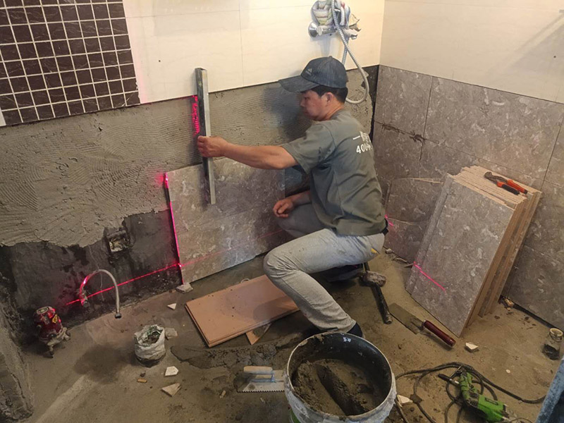 衛(wèi)生間貼磚施工：施工工藝流程; 基層處理--抹底子灰--彈線排磚--侵磚--鑲貼--擦縫--交工驗(yàn)收 用一比三的水泥砂漿打底,打底厚度5~~7mm，待底子灰干六七成干時(shí)候，按圖紙要求，進(jìn)行彈線，排磚。立好皮數(shù)桿，排磚形式有主要兩種直縫和錯(cuò)縫。當(dāng)?shù)孛嬗蟹核臅r(shí)候，注意安排好泛水。侵泡瓷磚，時(shí)間不少于兩個(gè)小時(shí)，陰干通常是3~~5小時(shí)。瓷磚在鑲貼時(shí)候，瓷磚下口坐在八字尺或直尺上。鋪貼的方式有離縫和無(wú)縫。鑲貼瓷磚從陽(yáng)角開(kāi)始，自下向上貼，瓷磚背面刀灰，貼上用力壓，用鏟刀木柄輕輕敲打，鋪貼時(shí)候砂漿飽滿，缺灰重貼，不得塞灰，貼6~~8塊，用靠尺校正。水管處先鋪周?chē)麎K磚，后鋪異型磚。最后擦縫。