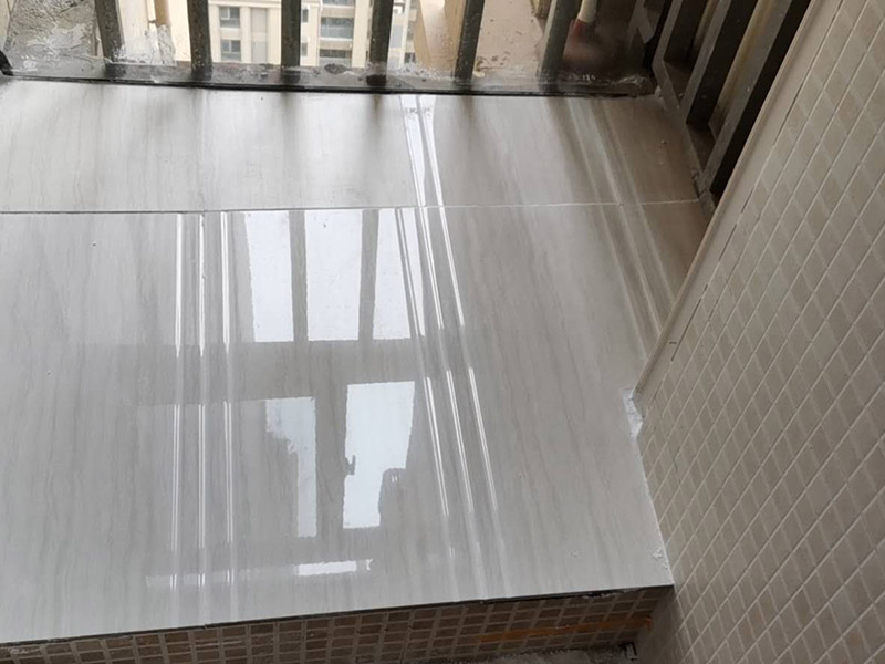 陽臺瓷磚鋪貼：準(zhǔn)備粘結(jié)劑前，瓷磚不應(yīng)浸水，但要用鋼絲刷除去磚背面的松散物質(zhì)，并用濕布抹去磚背的浮塵。然后按照生產(chǎn)商建議的比例將水或乳液放到攪拌桶中攪拌直至粘結(jié)劑均勻無結(jié)塊。初始攪拌后的粘結(jié)劑應(yīng)靜置在攪拌桶中，直到生產(chǎn)商推薦的熟化時間過后攪拌一下再使用。 在鋪壓瓷磚前，在瓷磚背面也批一薄層粘結(jié)劑。這種雙批法雖然用的材料和工時比較多，但卻能夠保證粘貼的質(zhì)量和耐久性。 在粘結(jié)劑量置晾時間內(nèi)，將準(zhǔn)備好的瓷磚鋪壓到位，垂直于梳理方向輕微搓動以排出磚下的空氣。鋪貼到位后用橡皮錘輕擊，用尺寸合適的十字定位架來調(diào)整表面平整度及接縫的平直。