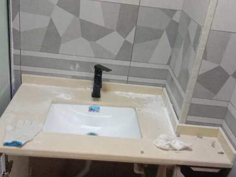 臺盆五金安裝：1.檢查預(yù)留給排水管路，安裝支撐洗面盆臺面的鋼制支架。 2.根據(jù)臺下盆包裝箱內(nèi)的臺面切割圖將臺面開孔打磨完畢。 3.按照安裝的龍頭和臺面尺寸正確切割龍頭安裝孔，打磨。 4.把洗面盆暫時(shí)放入已開好的臺面安裝口內(nèi)，檢查間隙，并做好記號。 5.檢查校驗(yàn)后，把洗面盆放平，在洗臉盆邊緣上口涂上硅膠密封材料后，把洗面盆小心放入臺面下，對準(zhǔn)安裝孔，跟先前的記號相校準(zhǔn)并向上壓緊，并使用廠家隨貨附帶的臉盆與臺面的連接件，將洗臉盆與臺面緊密連接。 6.臺下盆邊緣打膠。 7.安裝臺下盆上下五金件。 8.等密封膠硬化后，連接進(jìn)水和排水管件。