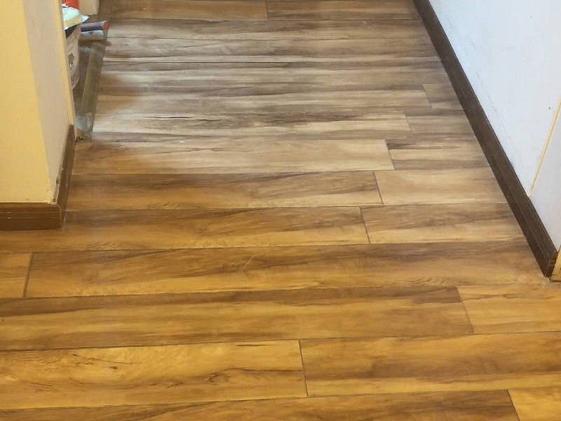 入戶門鋪地板：1、先對(duì)地面進(jìn)行找平，水平的誤差不能超過2毫米。地面要是不平，腳感就不好。再就是將邊、角部位等突起或有不平的地方進(jìn)行局部修整。再鋪防潮層，防潮層可以防止以后地板受潮。鋪平，接縫處要并攏。  2、然后就是安裝地板了，因?yàn)榈匕迨且e(cuò)落安裝的，先預(yù)鋪一下，將部分地板一分為二，要按尺寸來鋸，萬一鋸多了，地板損耗就大了。因?yàn)榈匕逵幸欢ǖ呐蛎浡?，因此鋪裝前要在其與墻面接觸的部位預(yù)留膨脹縫，以免地板起鼓。膨脹縫的大小一般和地板的膨脹系數(shù)有關(guān)系。粘合地板的膠水要用強(qiáng)化地板專用的，這種膠的污染比較小。不要隨便在市場(chǎng)上選非地板專用膠，地板本身就存在的污染上再增加污染源。  3、鋪前看好地板是否用對(duì)，再鋪設(shè)地板。在鋪設(shè)時(shí)，要一塊短的旁邊鋪一塊長的，這樣交叉鋪設(shè)地板就咬得住不易松動(dòng)，地板拼合后還要用工具敲緊。再下來就是銜接了，一般用地板壓條掩蓋。但也有用玻璃膠填充。