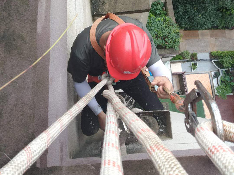 高空外墻防水涂刷：清理墻面基層，新舊面層務必處理干凈，不得有雜物和灰塵，以免影響粘結(jié)強度，涂刷防水涂料時基層應干燥?；鶎忧謇砉ば蛲瓿芍?，接下來，清理死角，也就是所謂的陰陽角、施工縫、伸縮縫等比較重要的部位進行處理，尤其注意的是泄水孔要加強處理，需要涂刷2-3遍防水底層涂料。