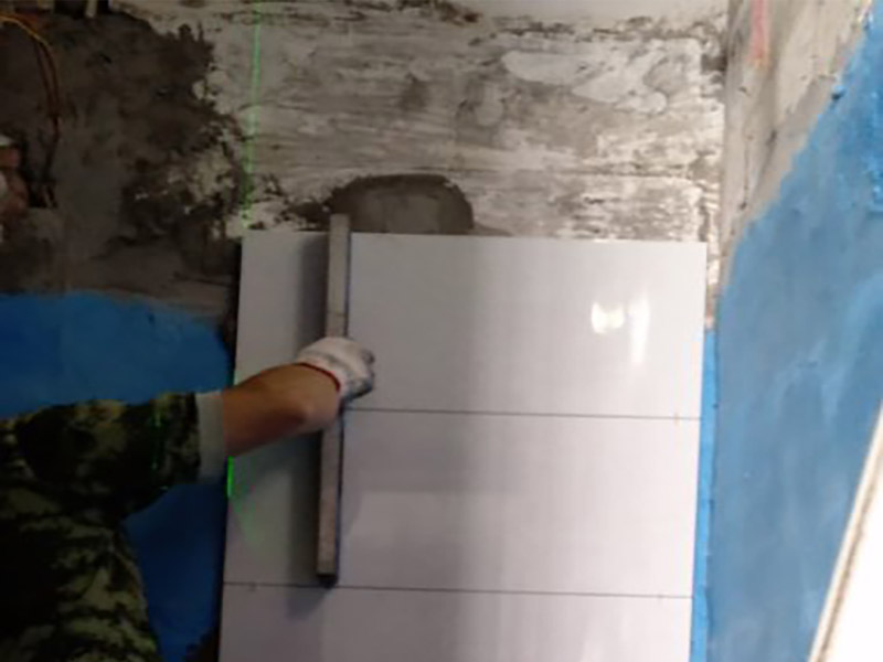 墻面瓷磚鋪貼施工：（1）基層處理：將塵土、雜物徹底清掃干凈，不得有空鼓、開(kāi)裂及起砂等缺陷。 （2）彈線：施工前在墻體四周彈出標(biāo)高控制線，在地面彈出十字線，以控制地磚分隔尺寸。 （3）鋪貼：鋪設(shè)選用1：3干硬性水泥砂漿，砂漿厚度25mm左右。鋪貼前將地磚背面濕潤(rùn)，需正面干燥為宜。把地磚按照要求放在水泥砂漿上，用橡皮錘輕敲地磚飾面直至密實(shí)平整達(dá)到要求。 （4）勾縫：地磚鋪完后24h進(jìn)行清理勾縫，勾縫前應(yīng)先將地磚縫隙內(nèi)雜質(zhì)擦凈，用專(zhuān)用填縫劑勾縫。 （5）清理：施工過(guò)程中隨干隨清，完工后(一般宜在24h之后)再用棉紗等物對(duì)地磚表面進(jìn)行清理