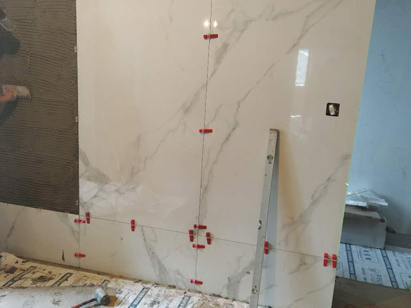 形象墻貼磚案例：將瓷麗貼粉劑倒入清水中攪拌成膏狀（混合比例：20kg粉劑＋6kg清水），攪拌完畢后需靜止放置約10分鐘，再略微攪拌一下才可使用，有助于增加貼結(jié)力。 用齒型刮板將膠漿涂抹于工作面之上，使之均勻分布，并成一條條齒狀。 在晾置時(shí)間內(nèi)將瓷磚揉壓于上即可。