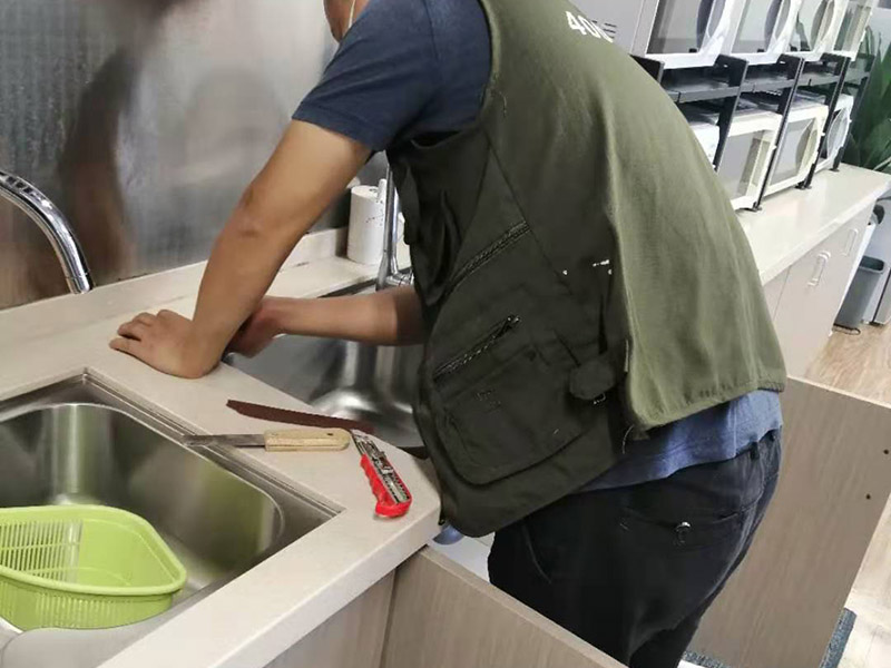 水槽安裝維修施工：第一步是安裝水龍頭。水龍頭有冷、熱之分，切勿搞錯位置。注意兩根進水管的位置，安裝方法及方式都大同小異，提前做好準(zhǔn)備，才不會出錯。為了避免空隙而設(shè)置的配件。用配置好的掛片，利用螺絲夾緊調(diào)平，利用硅膠封住水槽周邊和臺面。一端接入水槽的排水口，另一端接到地下的排水口，就可以了。注意兩者之間的銜接，是否牢固，是否密封等等。進排水是否通暢、密封是否得當(dāng)，是否滲水等等。如有滲水，立即返工。