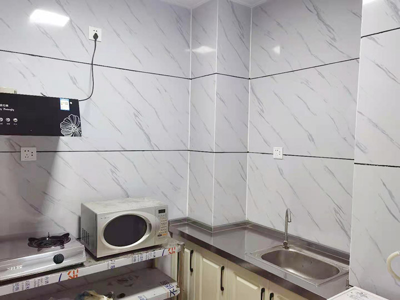 出租房廚房墻貼微晶板：將粘有圖案的轉(zhuǎn)移膜輕輕的撕離圖案的底紙，如果圖案有沒(méi)粘在轉(zhuǎn)移膜上的地方，可以用小刀輔助一下。先將轉(zhuǎn)移膜剪下的邊角料挑選個(gè)墻角的墻面測(cè)試一下墻面的性能，確定墻面沒(méi)問(wèn)題后再粘貼。如果墻面掉粉或在撕下轉(zhuǎn)移膜時(shí)會(huì)連同墻面漆一起粘下，請(qǐng)?zhí)幚砗笤龠M(jìn)行粘貼?！≠N圖案的時(shí)候，可以先將轉(zhuǎn)移膜的一角先粘在墻上，然后慢慢的將粘有圖案的轉(zhuǎn)移膜順著向下的方向貼在墻上，接著用卡片由圖案中間向四周的方向反復(fù)劃幾下，使墻貼更好粘在墻壁。