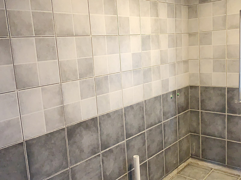 衛(wèi)生間墻磚鋪貼：首先應(yīng)除去基層表面的污垢，油漬，浮灰;除去基層上所有涂料層，膩子層;如果基層未能達到平整度要求，需對基層進行預(yù)先的找平處理。鋪貼瓷磚前需事先找好垂直線，以此為基準鋪貼的瓷磚高低均勻、垂直美觀;此外，施工前在墻體四周需彈出標高控制線，在地面彈出十字線，以控制地磚分隔尺寸。調(diào)制粘結(jié)劑：加水后將粘結(jié)劑漿料攪拌至潤滑均勻，無明顯塊狀或糊狀結(jié)塊，攪拌后的漿料靜置5-10分鐘后再稍加攪拌1-2分鐘即可使用。 將瓷磚平整地鋪貼在基層上，使用橡膠錘將瓷磚拍實鋪平。施工過程中，可小幅度轉(zhuǎn)動瓷磚，使?jié){料與瓷磚背面充分接觸。